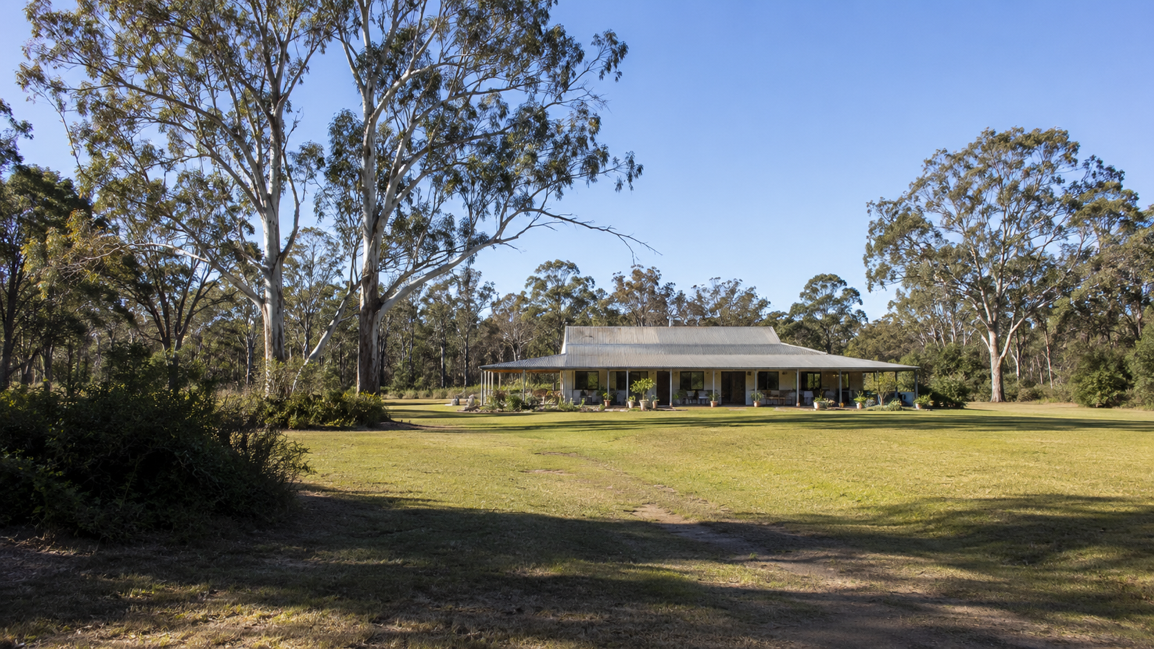 A rural home with cleared ground between the house and surrounding eucalypts